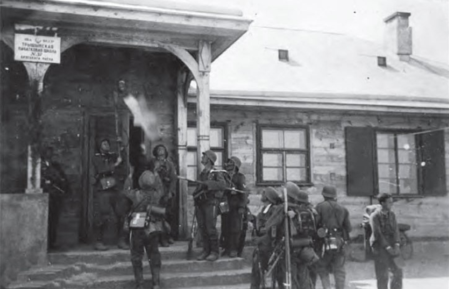 Гитлеровцы сбивают звезду со здания Тришинской школы в Бресте